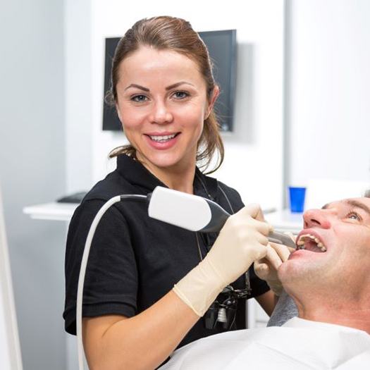 Dental team member scanning patient’s teeth