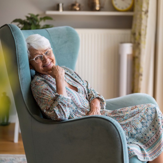 Happy older woman relaxing in armchair