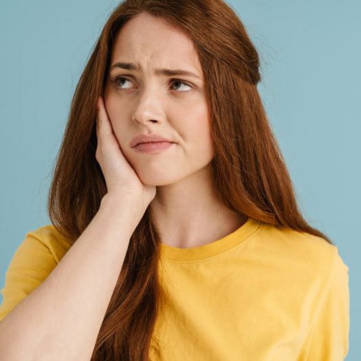 Frowning woman dealing with jaw pain