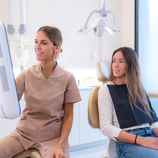 Patient and dental team member looking at computer monitor