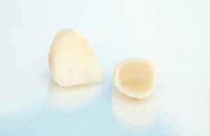 Two dental crowns sitting on slightly reflective surface