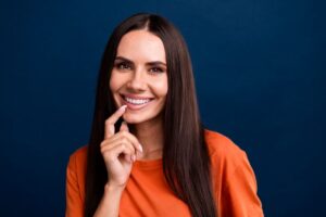 Smiling woman pointing at her beautiful teeth