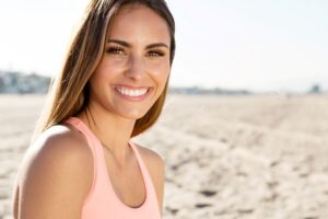 Woman with a beautiful smile, sitting on the beach